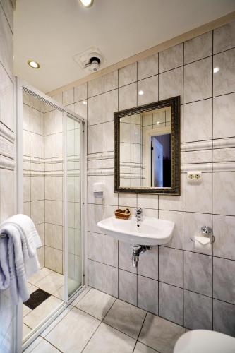 a bathroom with a sink and a shower at Kronen Gaard Hotel in Sandnes