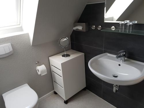 ビューズムにあるHaus Weimannのバスルーム(洗面台、トイレ、鏡付)