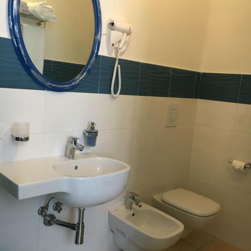 a bathroom with a sink and a toilet and a mirror at La Conchiglia in Sperlonga