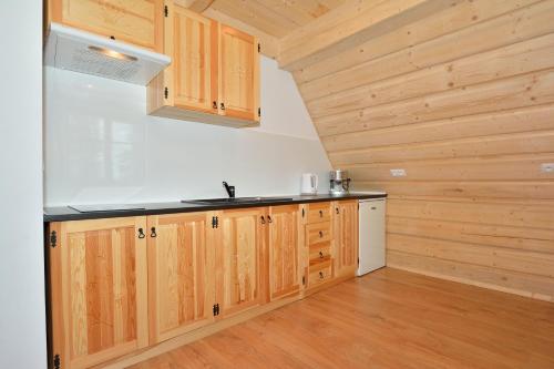 a kitchen with wooden cabinets and a sink at Długopolanka in Kościelisko