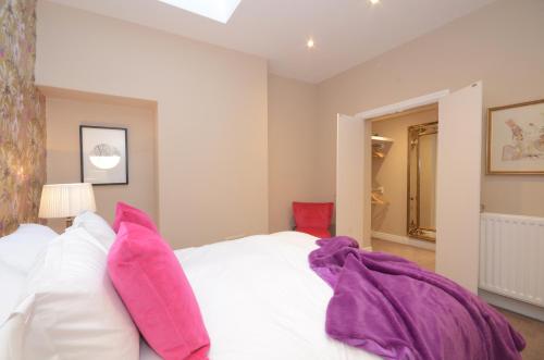 ヨークにあるLucy's Lodge- Most Stylish Apartment On Vibrant Bishy Roadのベッドルーム(ピンクの枕が付いた白いベッド付)