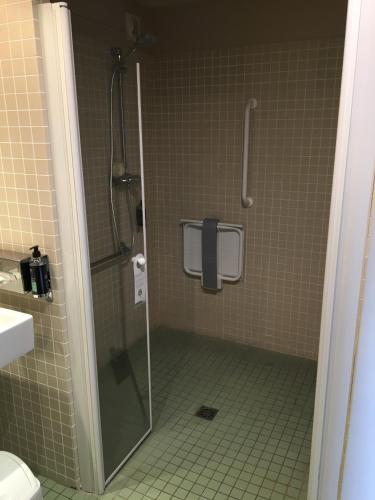 a shower with a glass door in a bathroom at Hotel du Casino in Saint-Valéry-en-Caux