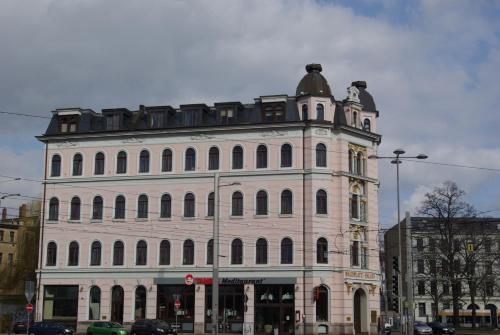 ein großes weißes Gebäude mit einem Uhrturm in der Unterkunft Apartments in der Jahnallee 20 Waldplatzpalais in Leipzig