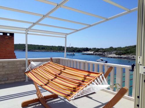 a hammock on a balcony with a view of the water at Apartments Dalmatino in Rukavac