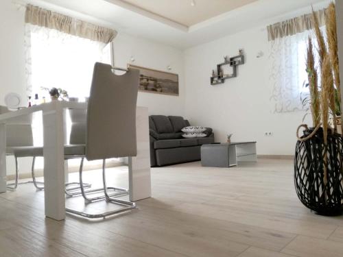 a white living room with a table and a couch at Apartments Dalmatino in Rukavac