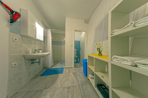 a white bathroom with a sink and a toilet at Apartment Nino in Skradin