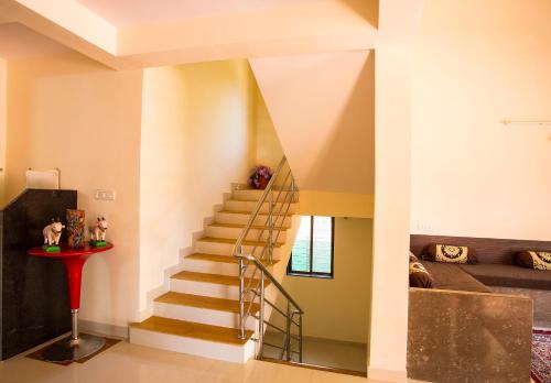 a staircase in a house with a living room at Shri Laxmi Narayan Bungalow in Mahabaleshwar