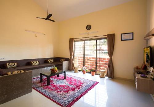 a living room with a couch and a table at Shri Laxmi Narayan Bungalow in Mahabaleshwar