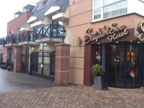 a store front of a brick building with a sign on it at SuyderSee Hotel in Enkhuizen