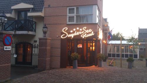 a restaurant with a sign on the front of a building at SuyderSee Hotel in Enkhuizen