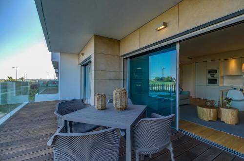 a table and chairs on the balcony of a house at Praia do Sal Resort in Alcochete