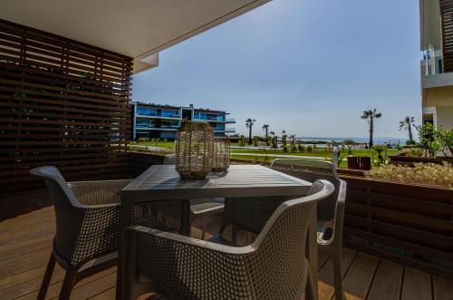 a table and chairs on a patio with a view of the ocean at Praia do Sal Resort in Alcochete