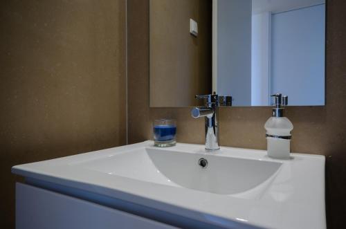 a white sink in a bathroom with a mirror at Praia do Sal Resort in Alcochete