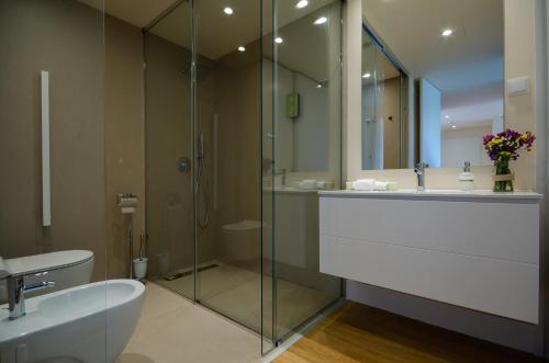 a bathroom with a glass shower and a sink at Praia do Sal Resort in Alcochete