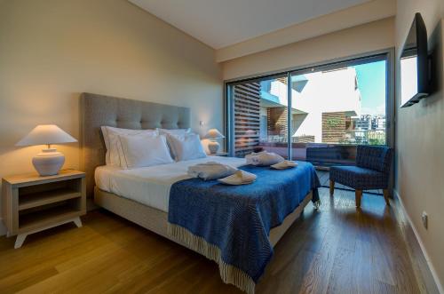 a bedroom with a bed and a large window at Praia do Sal Resort in Alcochete