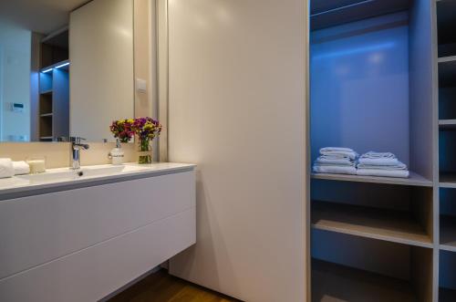 a bathroom with a sink and a mirror and towels at Praia do Sal Resort in Alcochete