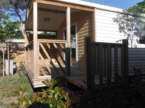 a tiny house with a porch and a deck at Camping l'Eléphant in Saint-Raphaël
