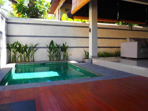 a swimming pool in the middle of a patio at Juada Garden in Seminyak