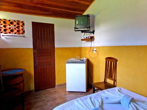 Cette chambre dispose d'un réfrigérateur et d'une télévision murale. dans l'établissement Quarto Maringá Minas, à Bocaina de Minas