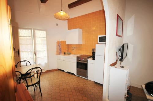 cocina con armarios blancos, mesa y nevera en 2EGA37 Studio en centre-ville, en Collioure