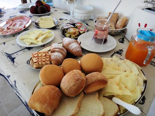 a table topped with plates of bread and pastries at Sa Fiorida case vacanze in Valledoria