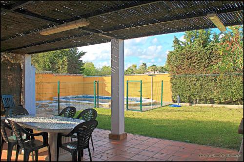 コニル・デ・ラ・フロンテーラにあるChalet Pradillo IIのパティオ(テーブル、椅子付)、テニスコートが備わります。