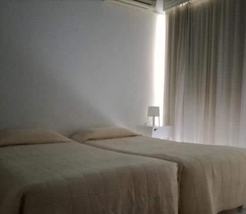 a bedroom with a bed and a lamp at Hotel Marko in Loutraki