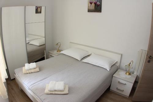 a bedroom with a bed with two towels on it at Apartmani Ivanković in Vrisnik