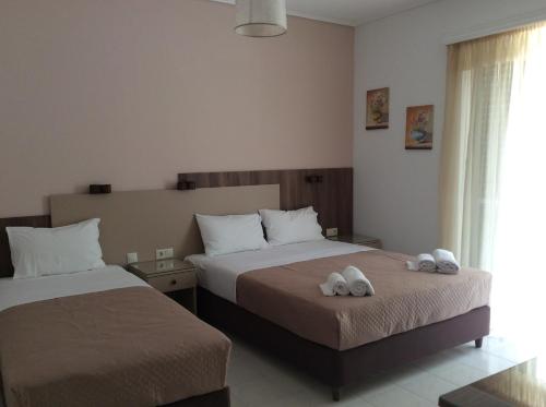 a bedroom with two beds with white towels on them at Erato Apartments in Petalidhion