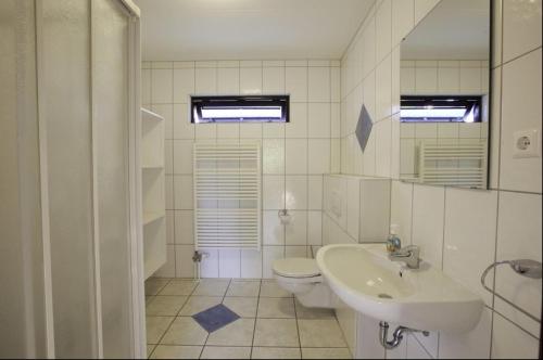 a white bathroom with a sink and a toilet at UplandParcs Dumel - gemütliches Haus in zentrumsnähe in Winterberg
