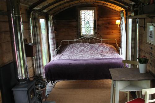オスウェストリーにあるOff the Railsの木造キャビン内のベッド1台が備わるベッドルーム1室を利用します。