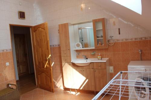 La salle de bains est pourvue d'un lavabo et d'un miroir. dans l'établissement Strēlnieku prospekts Villa 44, à Jurmala