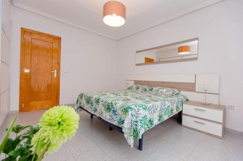 1 dormitorio con 1 cama y puerta de madera en Villa EGO, en Torrevieja