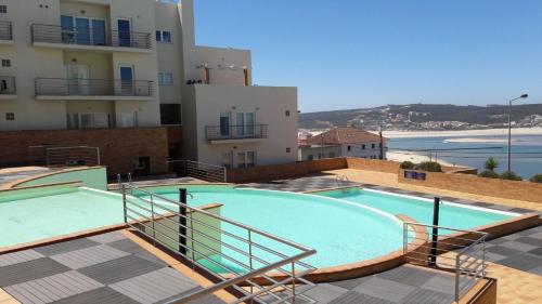 a large swimming pool next to a building at Pé na Praia da Foz in Foz do Arelho