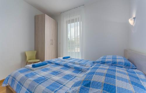 ein blau-weißes Bett in einem Zimmer mit Fenster in der Unterkunft Apartment Marina in Novigrad Istria