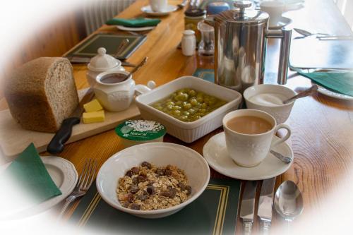 a table with a breakfast of bread and a cup of coffee at Rye Hill Farm in Hexham