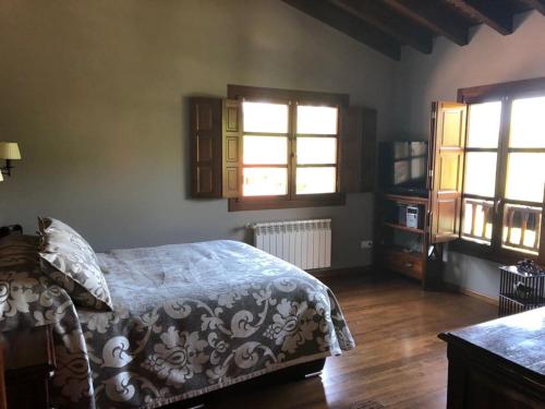 a bedroom with a bed and two windows at Lugar Meluerda in Meluerda