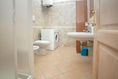 a bathroom with a toilet and a sink at Fronte Mare Capo Testa in Santa Teresa Gallura