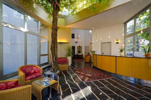 a lobby with a tree in the middle of a building at Hotel Carlton in Lignano Sabbiadoro