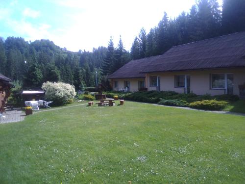 a house with a yard with a grass yard at Ośrodek Wczasowy "GRONOSTAJ" in Rajcza