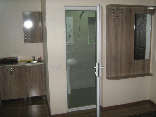 La salle de bains est pourvue d'une douche et d'une porte en verre. dans l'établissement gorda, à Koutaïssi