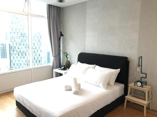 a bedroom with a white bed with a large window at VORTEX SUITES KLCC by PNUT With NETFLIX in Kuala Lumpur