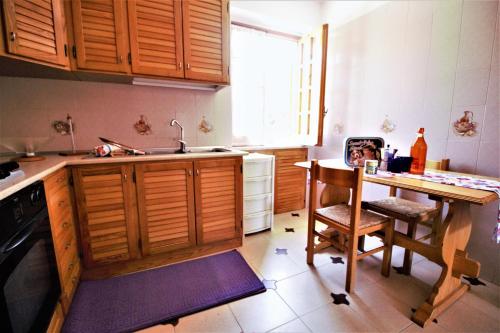 a kitchen with wooden cabinets and a table and a sink at holidaycasa Leone - Con posto auto a 200mt dal Mare in Sperlonga