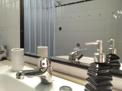 レッジョ・ディ・カラブリアにあるB&B "Al Calopinace"のバスルーム(洗面台、2つの蛇口、鏡付)