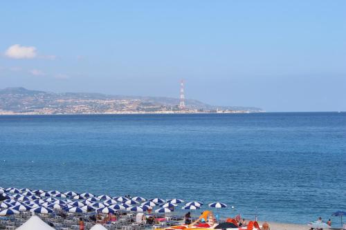 a group of people on a beach with umbrellas at BB Oasis in Scilla