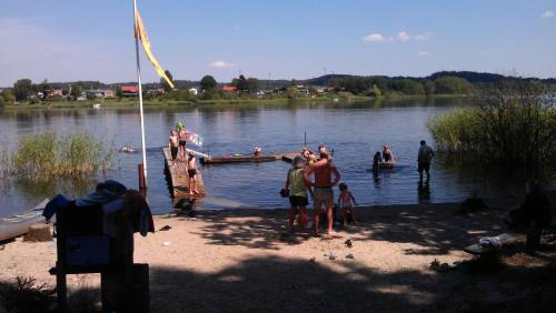 a group of people standing on the shore of a lake at Silkeborg Sø Camping Apartments in Silkeborg