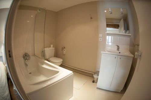 a bathroom with a tub and a toilet and a sink at Hôtel Les Chevaliers in Laon