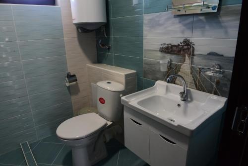 a small bathroom with a toilet and a sink at Hotel Active Apartments in Targovishte