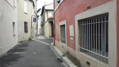 an alley with a red building and a gate at le 4bis in Avignon