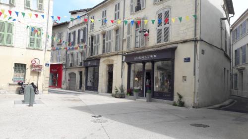 a street with flags and a store on a city street at le 4bis in Avignon